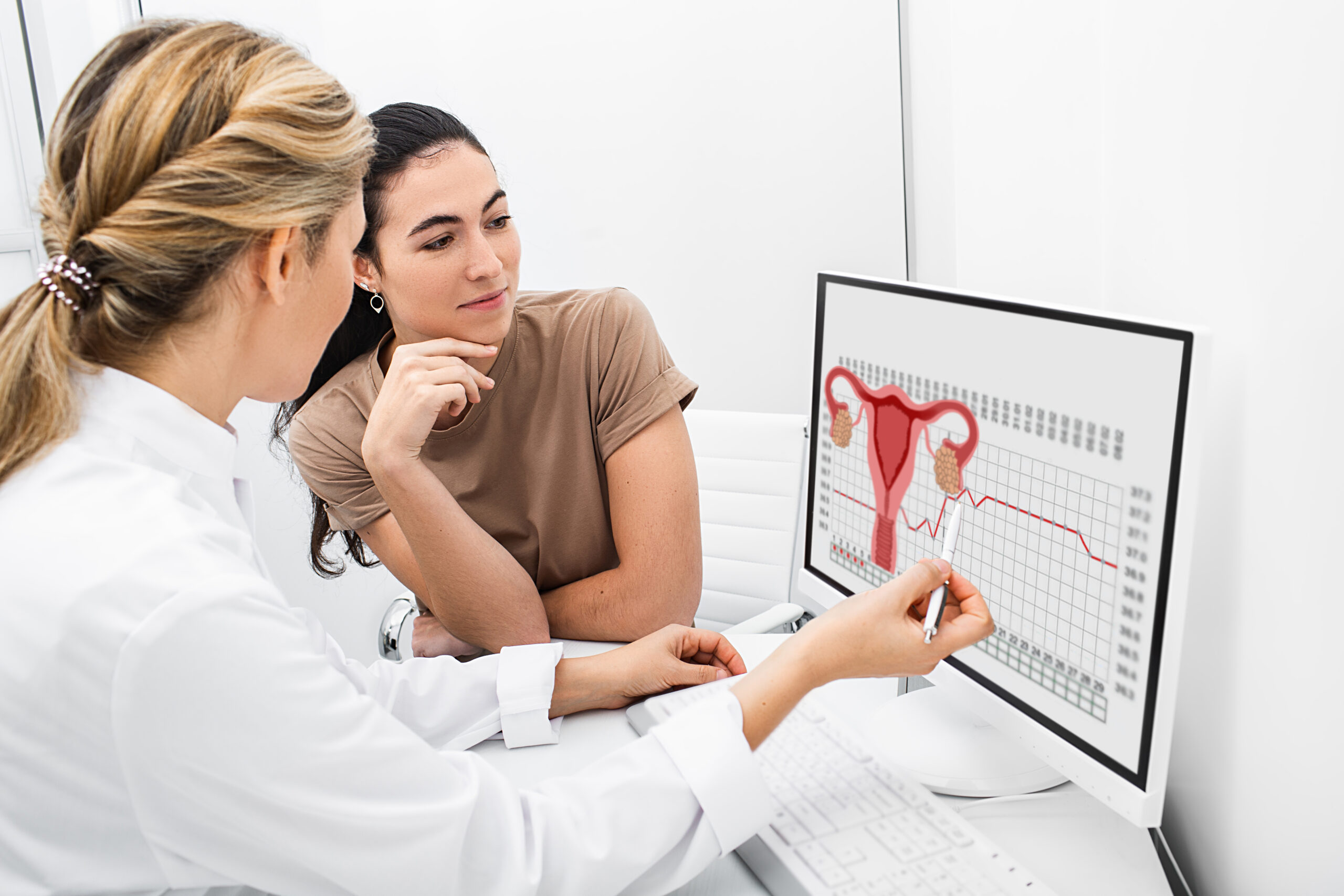 Gynecologist communicates with her patient, indicating the menstrual cycle on the monitor. The reproductive specialist calculated the period of ovulation for the patient.