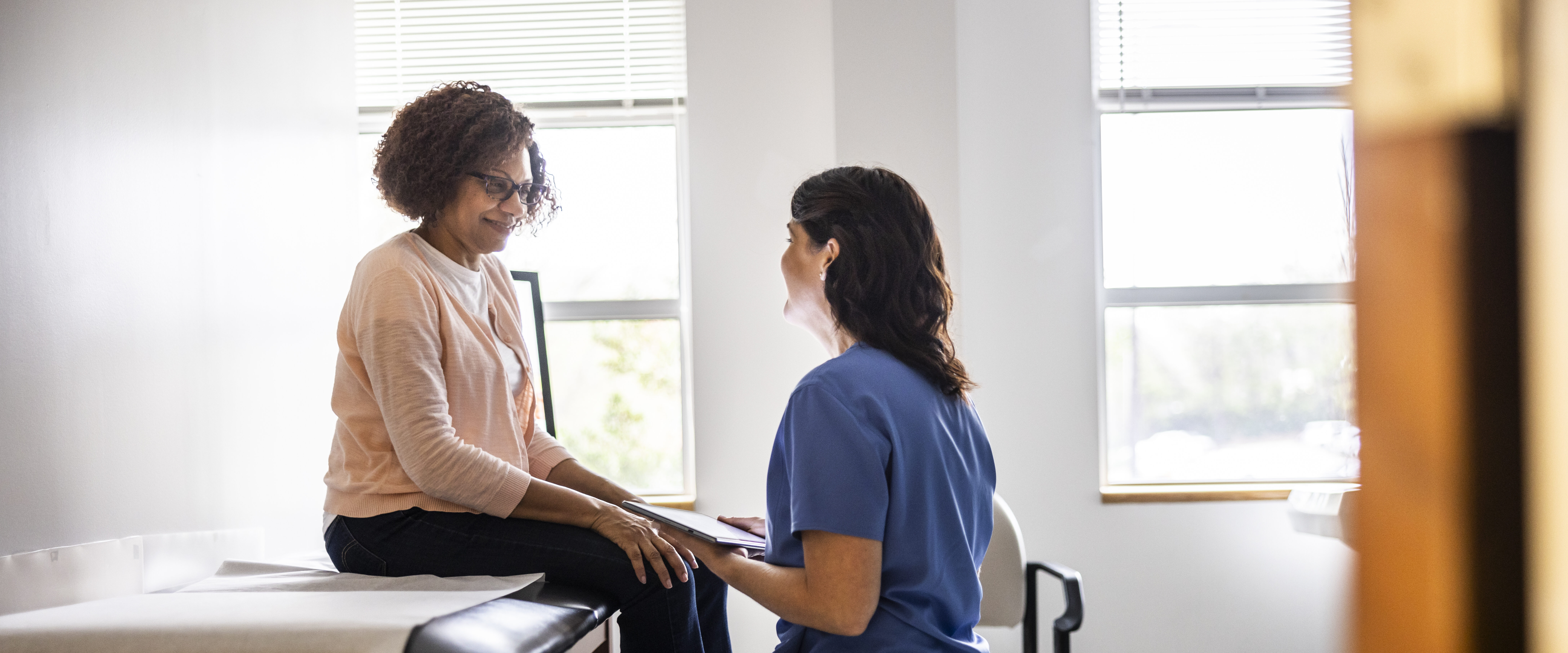 Doctor and senior woman discussing treatment in doctors office