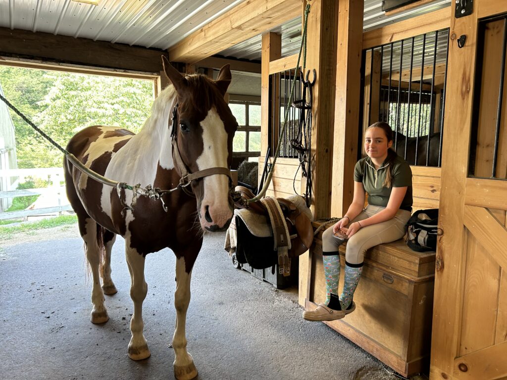 Molly sitting in stable with horse