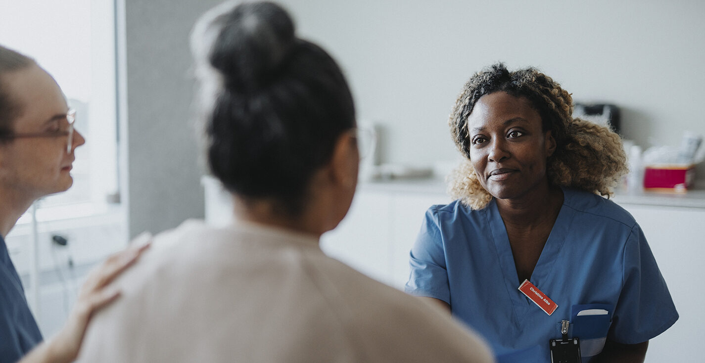 Smiling female medical worker informing good news to patient at hospital