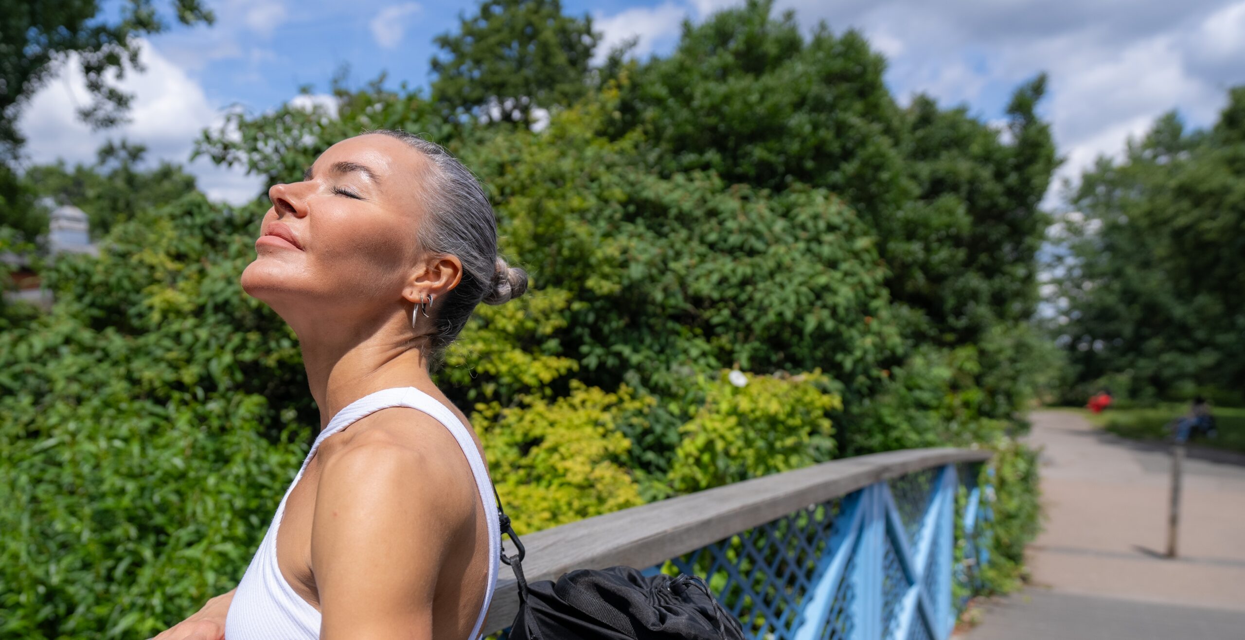 Woman after jogging on a sunny day over a bridge
