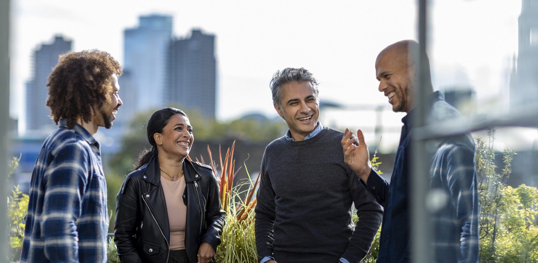 Friends talk outside near a skyline of a city