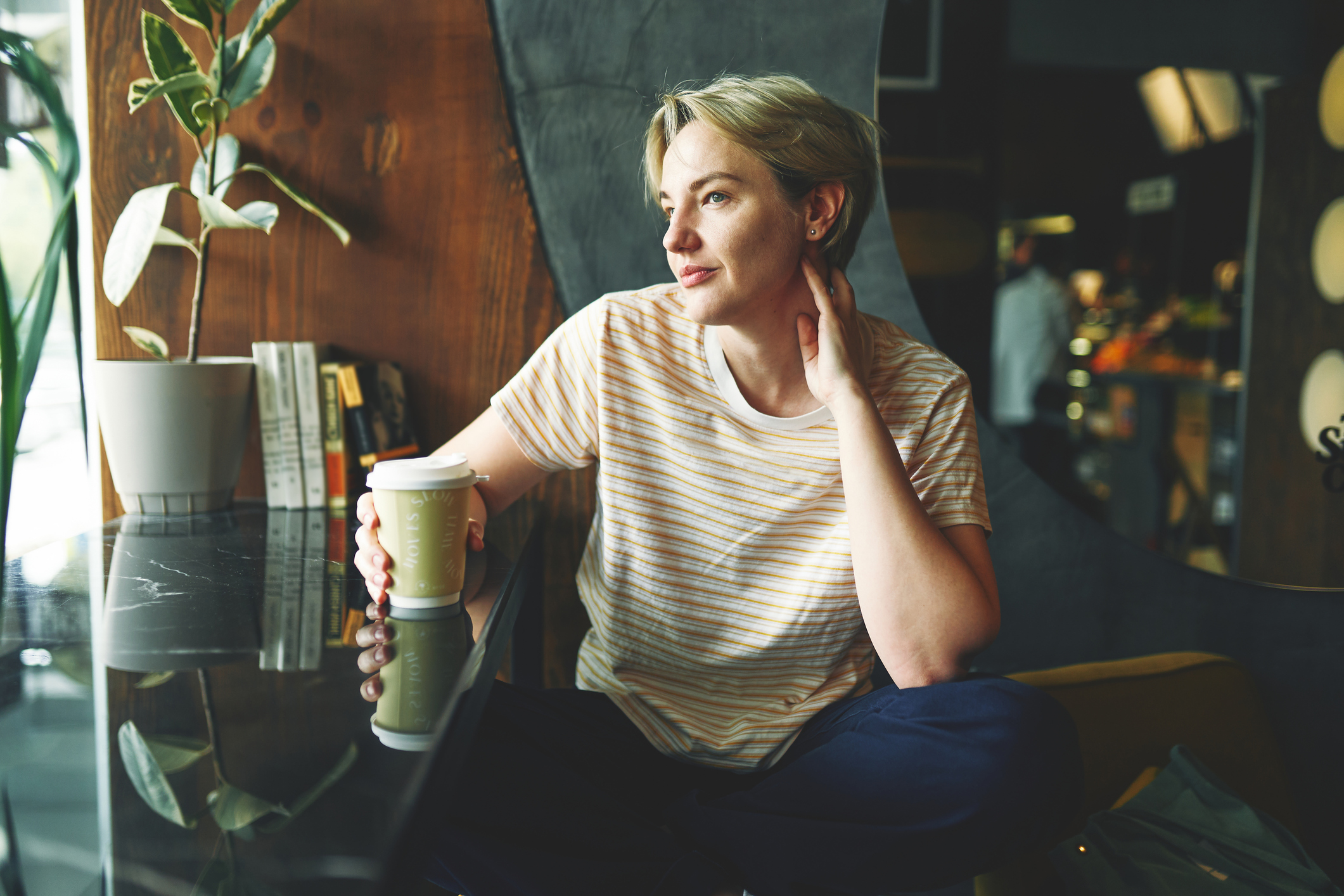 Businesswoman sitting at workstation in design firm , looking at window