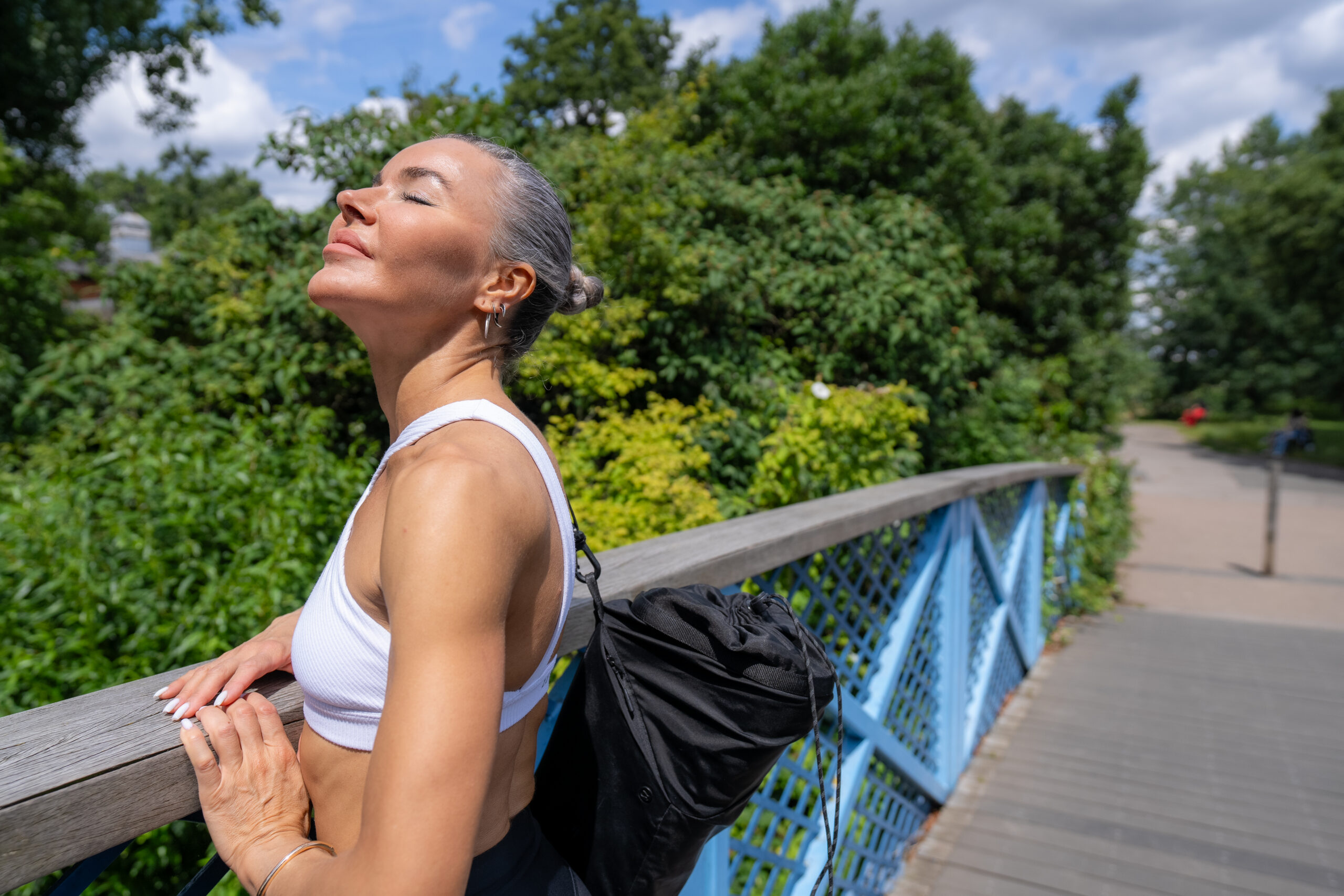 Woman after jogging on a sunny day over a bridge