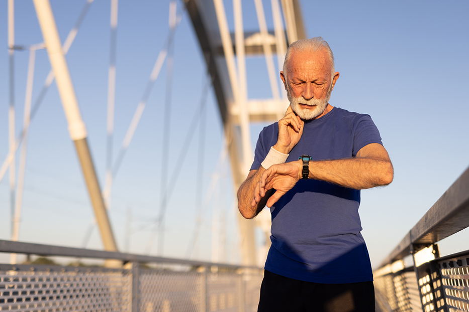 Heat-Related Illness: Recognizing and Preventing Summer’s Hidden Danger Older male checking his pulse on his neck over a bridge