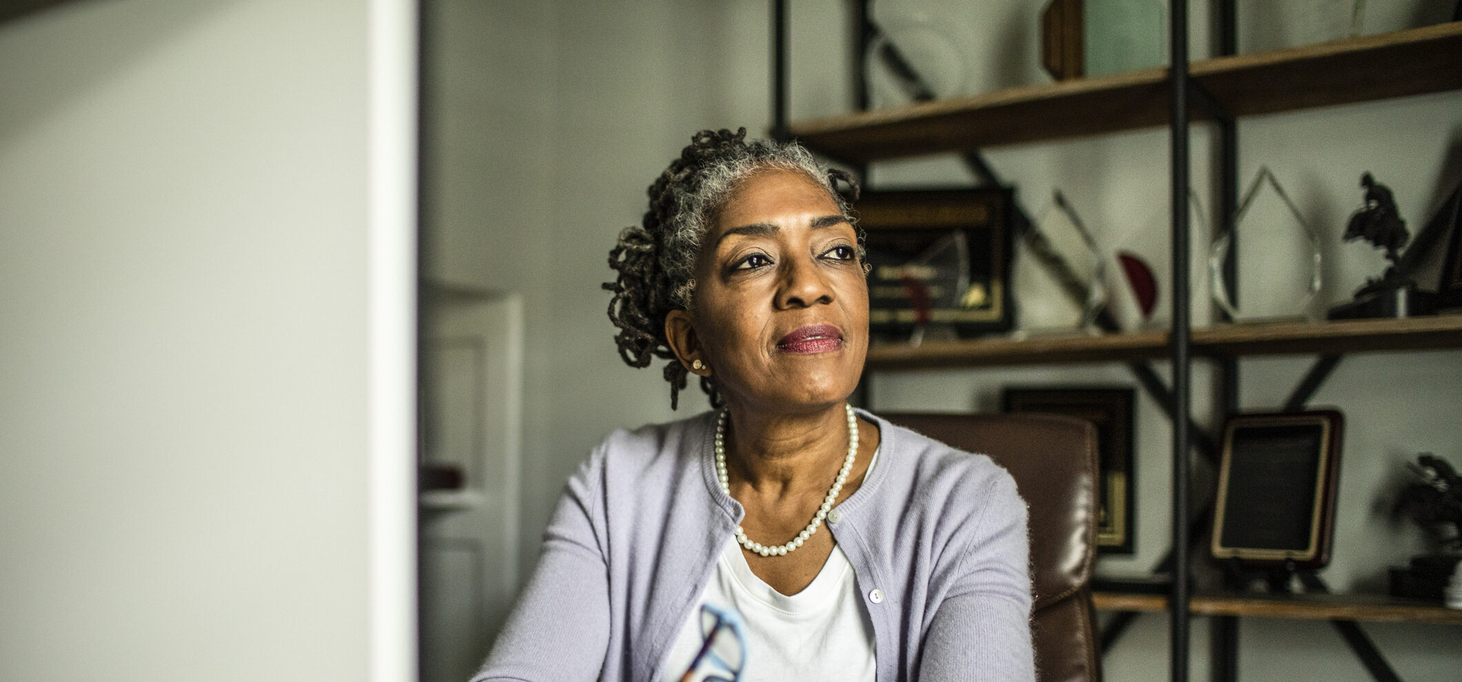Portrait of senior woman at desktop computer in home office