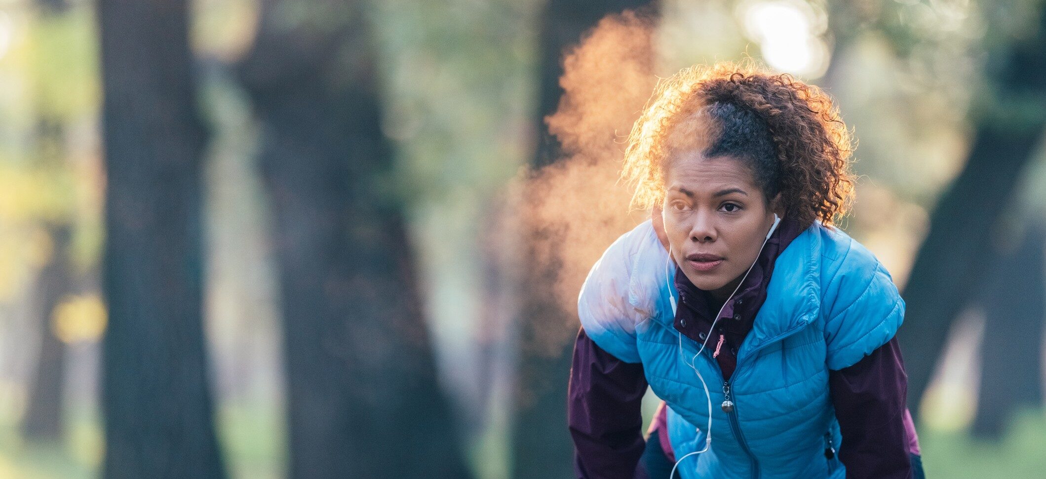 Women running with a vest in the fall with breath steam